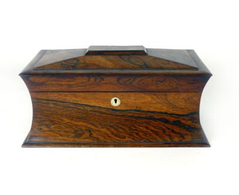 An early 19th Century rosewood tea caddy of sarcophagus form with fitted interior of a pair of hinged covered boxes and a cen