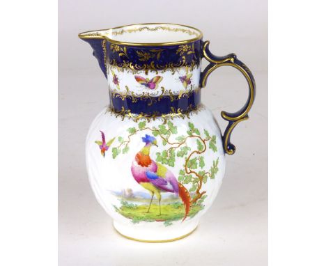 A Royal Worcester cabbage leaf jug in the 18th century style, decorated with birds and butterflies beneath a blue and gilt ri