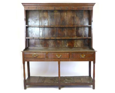 An oak dresser, 18th Century and later, two shelf plate rack with wrought iron spoon hooks on a base with three frieze drawer