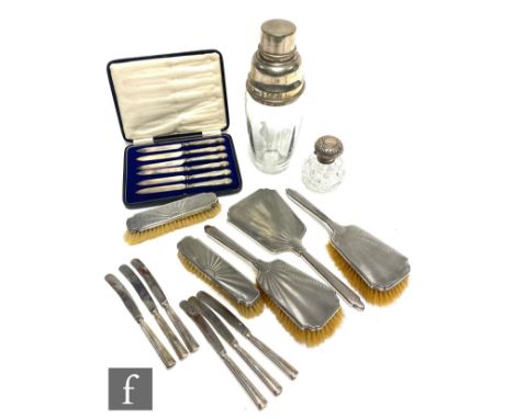 A hallmarked silver backed five piece brush set with engine turned decoration, Birmingham 1932, with a silver topped scent bo
