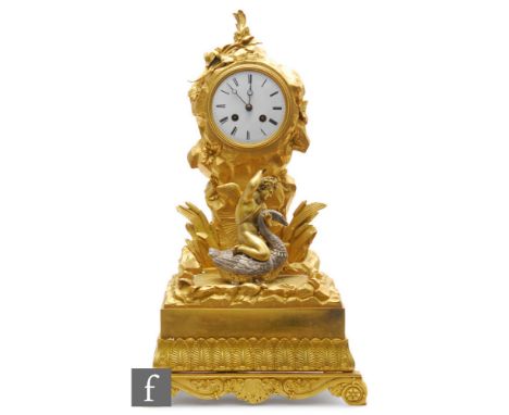 A late 19th century French gilt mantle clock, the circular white enamelled dial with eight day striking movement surmounted w