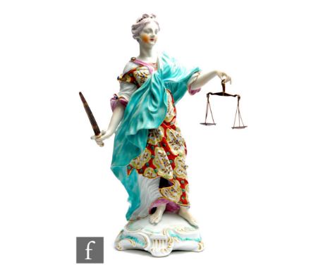 A late 18th to early 19th Century Derby figure modelled as Justice stood in a burnt orange and gilt dress draped in a blue ro