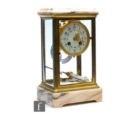 An Edwardian brass mantle clock with mercury suspended pendulum and floral dial, eight day movement striking on a gong, in gl