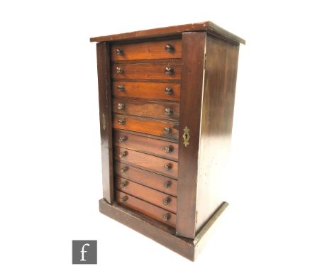 A late 19th to early 20th Century stained pine collectors cabinet in the form of a Wellington chest, fitted with ten drawers 