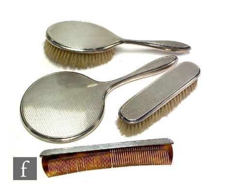 A hallmarked silver four piece backed dressing table set with engine turned decoration, Birmingham 1975. 
