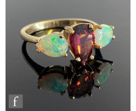 A 9ct hallmarked opal and&nbsp;rhodolite three stone ring, central&nbsp;rhodolite flanked by pear shaped opals, weight 3g, ri