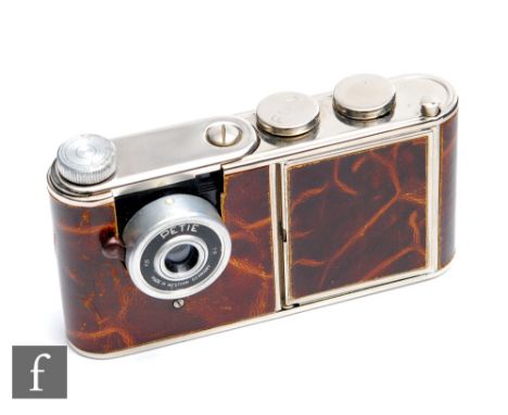 A 1950s West German 'Petie' vanity camera, brown marble leather with chrome hardware, the push button reveling hinged compact