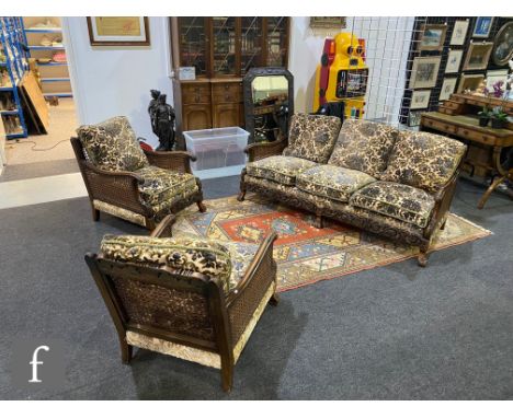 Amended description - A 1930s carved beech bergere three piece suite in the Chippendale style, scroll rail over double cane s