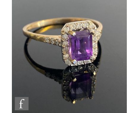 A 9ct hallmarked amethyst and diamond cluster ring, central emerald cut amethyst, length 7mm, within a diamond set border and