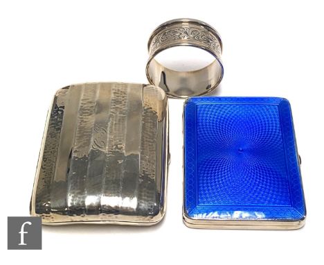 Two hallmarked silver rectangular cigarette cases, one plain the other with blue enamel decoration, with a single silver napk