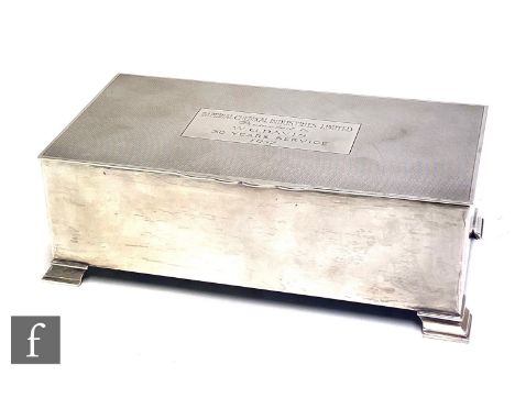 A hallmarked silver rectangular cigarette box with engine turned decoration encompassing presentation engraving and raised on