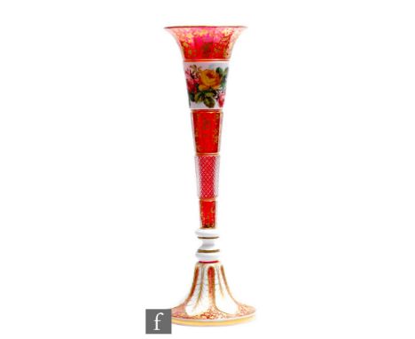 A large 19th Century Bohemian ruby glass vase in the manner of Moser of Neuwelt, the tall trumpet form body cased in opal ove