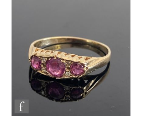 An early 20th Century 9ct hallmarked ruby and diamond seven stone boat shaped ring, three rubies spaced by diamonds to plain 