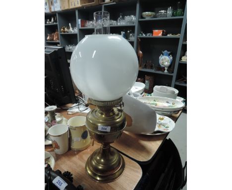 a vintage brass bodied electric lamp with milk glass shade