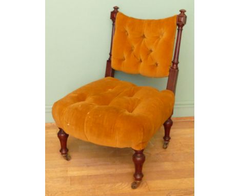 A 19th century mahogany framed button back nursing chair, raised on tapering fluted supports terminating in brass casters, 80
