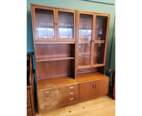 A 20th century G-Plan teak twin door glass display unit opening to reveal four shelves with twin cupboard doors below raised 