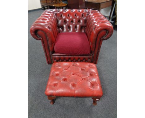 A red button leather Chesterfield club armchair and a similar footstool 
