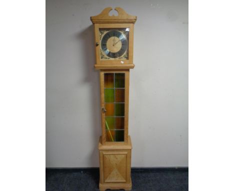 A continental blond oak cased longcase clock with leaded panel door 