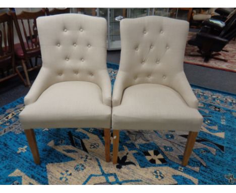 A pair of contemporary high back lady's chairs in beige button fabric 