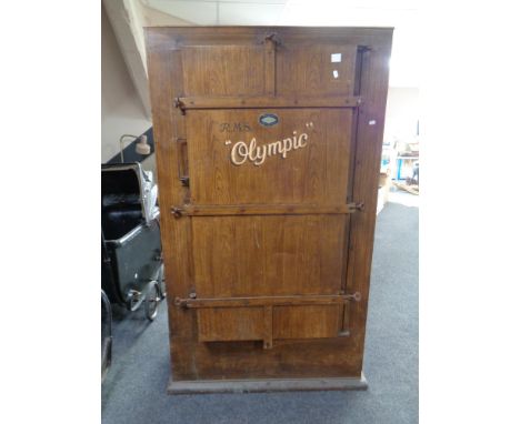 An early 20th century metal storage cabinet bearing decoration R.M.S. Olympic, in a wood effect finish, 96cm by 65cm by 164cm