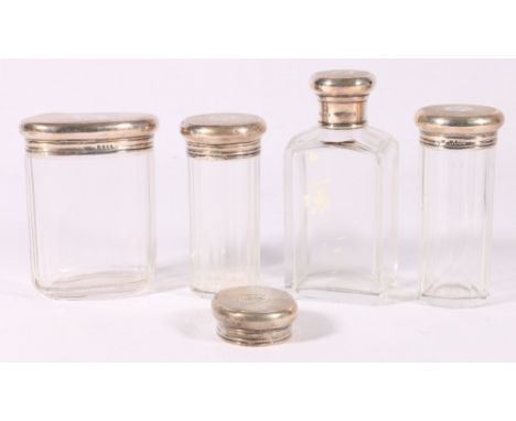 Set of four engine-turned silver covered glass toilet jars, with matching monogram, 10cm and a matching lid. (5)