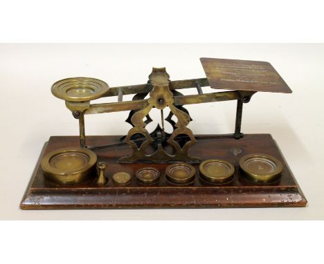 Set of Victorian brass postal scales on wooden plinth base with weights (incomplete), 32cm long.