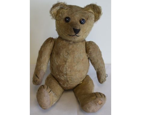 Vintage teddy bear, the golden mohair jointed body with humped back and elongated snout, button eyes, stitched muzzle and paw