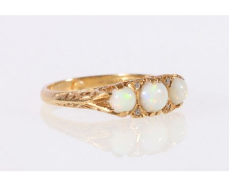 18ct gold opal three stone diamond ring in a scroll setting, marked "18ct".