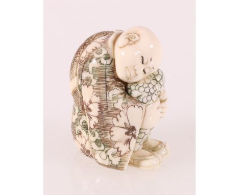 Netsuke of a seated boy clasping his knees, inked colour, signed to base, Meiji, 3.5cm.