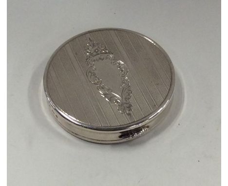 An engine turned silver compact with engraved decoration. Approx. 75 grams. Est. £30 - £50.