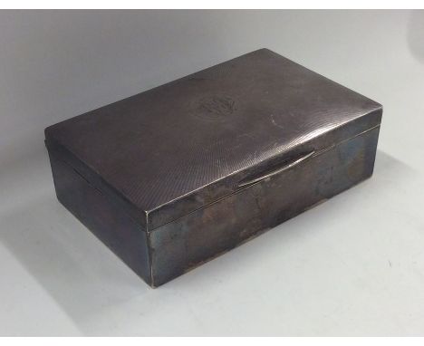 A rectangular engine turned silver cigarette box. Birmingham. By JD&amp;S. Approx. 367 grams. Est. £30 - £50.