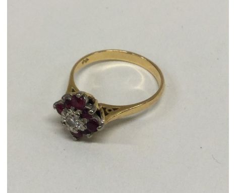 An attractive 18 carat ruby and diamond daisy head cluster ring in claw mount. Approx. 3.3 grams. Est. £100 - £150.