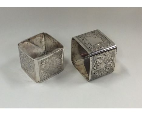 A pair of Victorian silver napkin rings decorated with flowers and leaves. London. By JH. Approx. 90 grams. Est. £25 - £35.