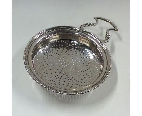 A good Georgian silver lemon strainer with pierced bowl and gadroon rim. Approx. 53 grams. Est. £150 - £200.