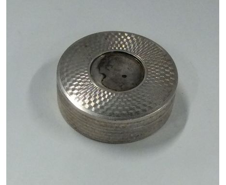 A small circular engine turned silver box with gilt interior. Approx. 30 grams. Est. £15 - £20.