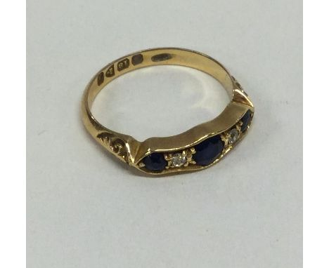 A sapphire and diamond five stone half hoop ring set in 18 carat gold. Chester. Approx. 3.4 grams. Est. £100 - £150.