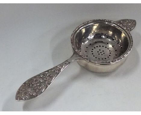 A heavy silver tea strainer on stand with scroll handle. Birmingham. By HU. Approx. 97 grams. Est. £60 - £80.