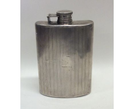 A large silver engine turned hip flask with hinged top. Approx. 195 grams. Est. £100 - £150.