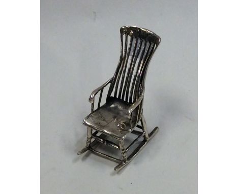 A novelty silver doll's house rocking chair. Approx. 10 grams. Est. £20 - £30.