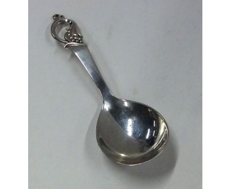 A stylish silver caddy spoon with scroll decoration. Approx. 13 grams. Est. £40 - £60.