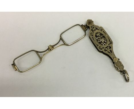 A pair of French silver gilt lorgnettes attractively decorated with flowers and leaves. Approx. 16 grams. Est. £60 - £80.