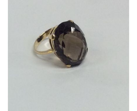 A brown topaz single stone ring in 9 carat claw mount. Approx. 10 grams. Est. £100 - £150.