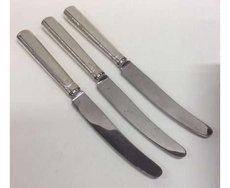 A set of three Georgian silver knives with engraved decoration. Approx. 268 grams. Est. £25 - £35.