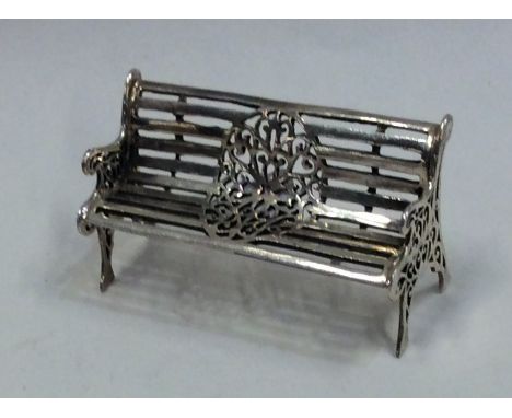 A novelty doll's house model of a park bench. Approx 20 grams. Est. £20 - £30.