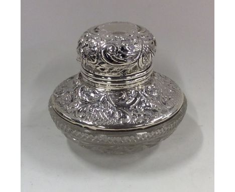 A silver embossed top inkwell with cut glass base. Approx. 307 grams. Est. £25- £35.