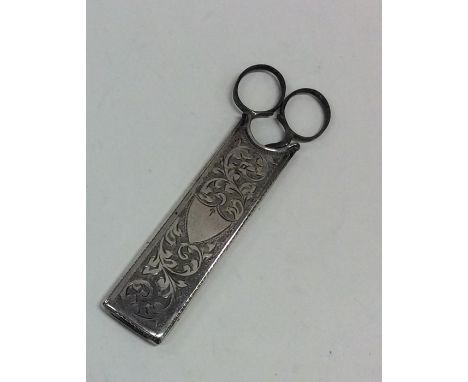 An unusual pair of steel scissors contained within a silver case engraved with flowers and leaves. Approx. 27 grams. Est. £20
