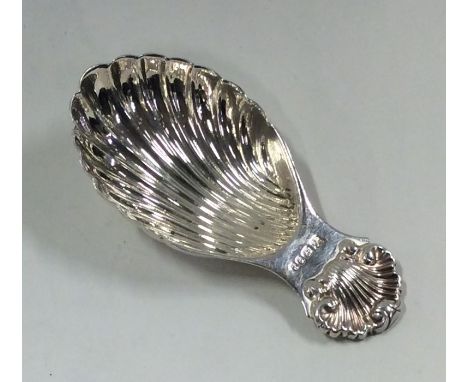 A silver caddy spoon with fluted bowl and shell thumb piece. Approx. 20 grams. Est. £25 - £35.