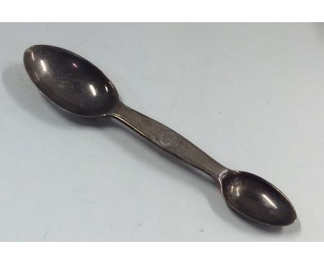 A novelty double ended silver medicine spoon with engine turned decoration. Est. £60 - £80.