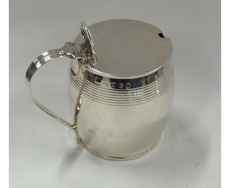 A silver barrel shaped mustard pot with hinged top. Approx. 184 grams. Est. £40 - £60.