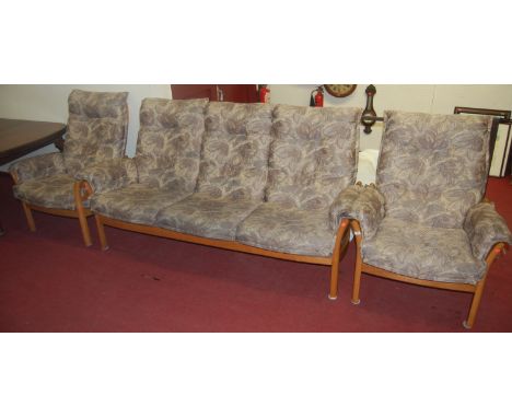 An Ercol light elm three piece suite comprising triple settee, and pair of armchairs, each with floral upholstered cushions